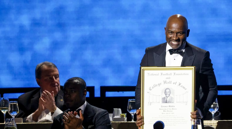 Former New Mexico wide receiver Terance Mathis holds up his College Football Hall of Fame Award during the National Football Foundation Awards Dinner, Tuesday, Dec. 5, 2023, in Las Vegas. (AP Photo/Ian Maule)