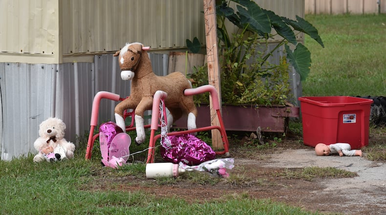 A memorial of flowers and stuffed toys is outside the mobile home of Christopher McNabb in Covington on Friday. McNabb is accused of killing his 15-day-old newborn inside the home by striking her in the head, according to investigators. HYOSUB SHIN / HSHIN@AJC.COM