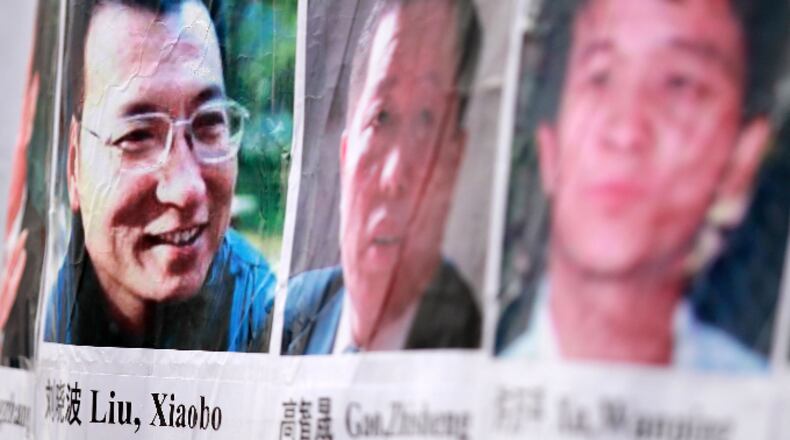 Pictures of Chinese dissidents, including Nobel Prize laureate Liu Xiaobo (L), are seen on a banner during a rally for Liu December 10, 2010 in Washington, DC.