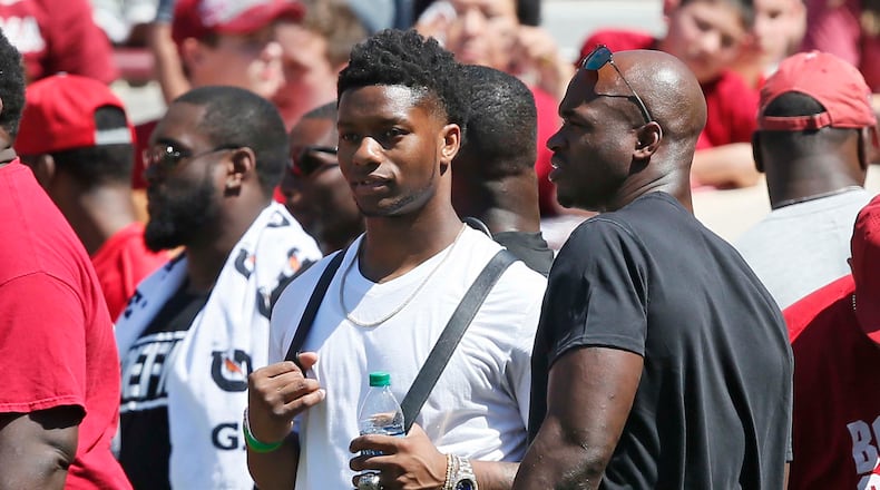 Former Oklahoma players Joe Mixon, left, and Adrian Peterson, right, talk during the annual Oklahoma NCAA college spring football game in Norman, Okla., Saturday, April 8, 2017. (AP Photo/Sue Ogrocki)