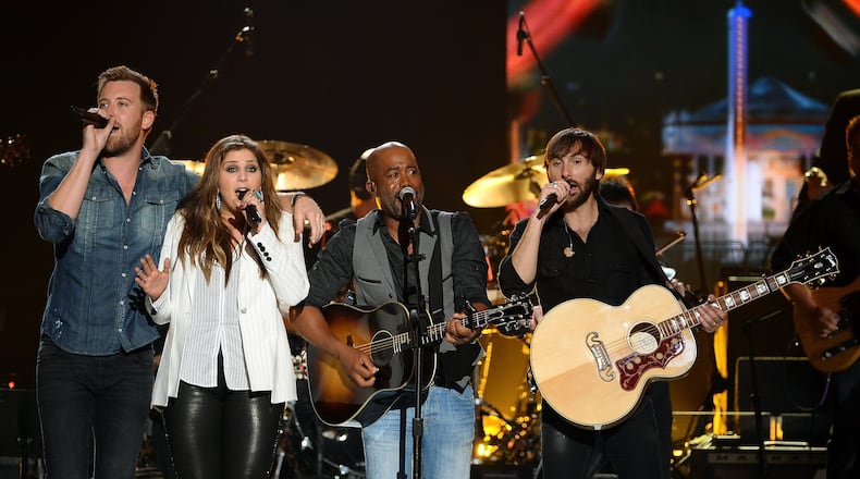 Members of Lady Antebellum sing with Darius Rucker (second from right). The trio is going on tour with Rucker this summer.