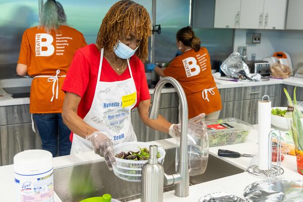 Volunteer Marlena Williams washes lettuce at the Ronald McDonald House in Atlanta. Williams is part of a group of volunteers with Atlanta-based Novelis who now prepare and serve meals twice a month at the organization's Peachtree Dunwoody House. (Phil Skinner for the AJC)
