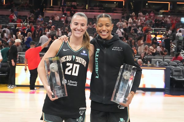 New York Liberty's Sabrina Ionescu, left, holds the 3-point contest trophy while New York Liberty's Natasha Cloud holds the skills challenge trophy during the WNBA All-Star basketball weekend, Friday, July 18, 2025, in Indianapolis. (AP Photo/Michael Conroy)