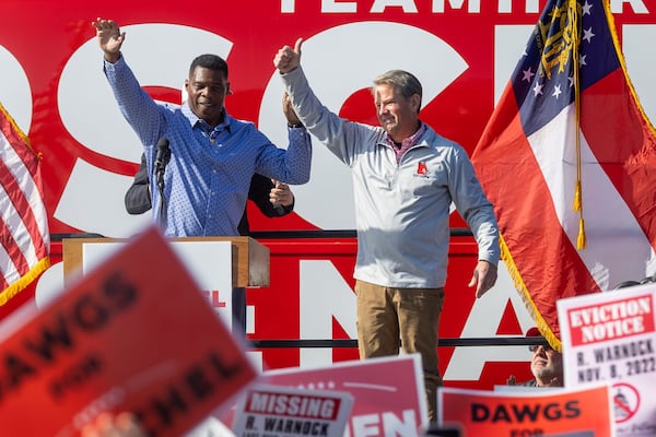 Georgia Gov. Brian Kemp, right, and Republican U.S. Senate hopeful Herschel Walker wave to the crowd at the end of a rally in Smyrna, Georgia, on Saturday, Nov. 19, 2022. (Steve Schaefer/Atlanta Journal-Constitution/TNS)