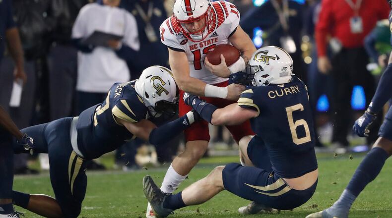 Georgia Tech linebackers David Curry (6) and Jordan Domineck (42) stop North Carolina State quarterback Devin Leary (13) after a short gain during the first half  Thursday, Nov. 21, 2019, at Bobby Dodd Stadium in Atlanta.