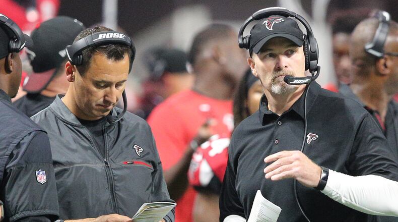 Falcons offensive coordinator Steve Sarkisian and head coach Dan Quinn confer on the sidelines against the Packers in a NFL football game on Sunday, September 17, 2017, in Atlanta.    Curtis Compton/ccompton@ajc.com