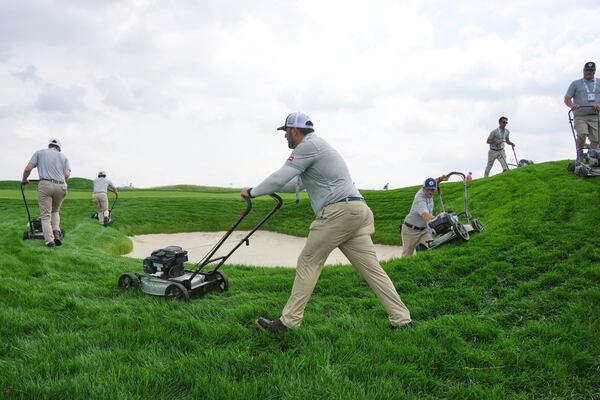 The rough surrounding a fairway bunker on the 18th hole gets trimmed during a practice round for the 2025 US Open golf championship at Oakmont Country Club in Oakmont, Pa., Monday, June 9, 2025. (AP Photo/Gene J. Puskar)