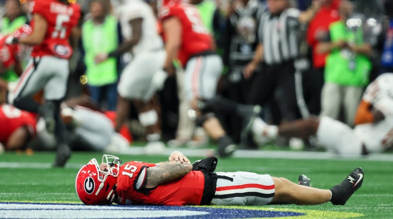 Georgia quarterback Carson Beck (15) lays on the ground after getting hit and fumbling the ball for a Georgia turnover on the last play of the first half against Texas in the 2024 SEC Championship game at Mercedes-Benz Stadium on Saturday, Dec. 7, 2024, in Atlanta. (Jason Getz/The Atlanta Journal-Constitution/TNS)