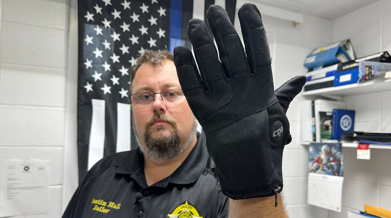 Nelson County, Ky., jailer Justin Hall shows an electric shock glove that is used at his facility, Thursday, Aug. 13, 2026, in Bardstown, Ky. (AP Photo/Dylan Lovan)