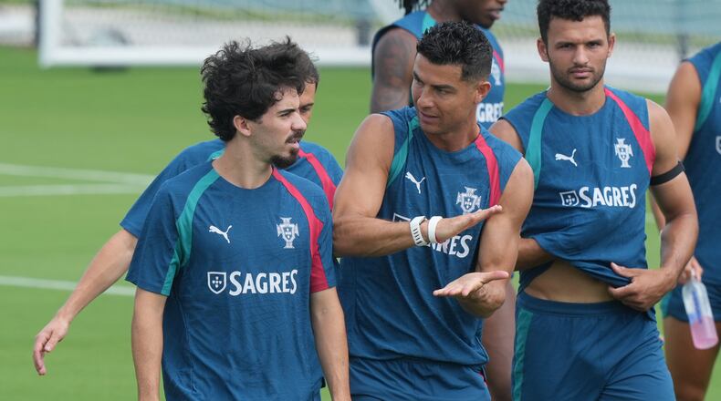 Portugal's Cristiano Ronaldo, center talks to Vitinha during the men's national soccer team World Cup training session Thursday, June 25, 2026, in Palm Beach Gardens, Fla. (AP Photo/Marta Lavandier)