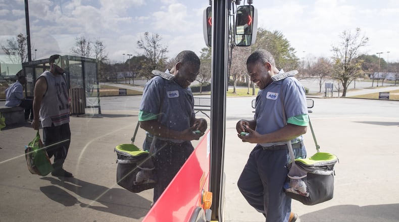 Simon Tshimanga of Duluth jokes with a Gwinnett County transit bus driver while boarding a bus at the Gwinnett Transit Center in Duluth, Friday, February 23, 2018. Simon, a second shift custodian with ABM, uses the transit system to get to work. ALYSSA POINTER/ALYSSA.POINTER@AJC.COM