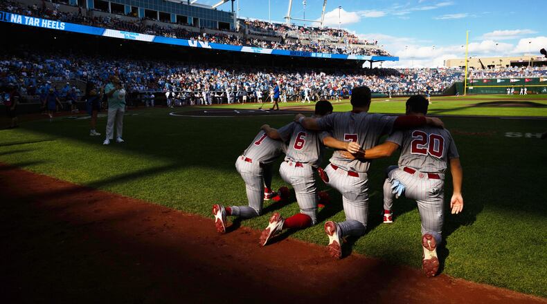 Oklahoma's Jason Walk (1), Kyle Branch (6), Jaxon Willits (7) and Trey Gambill (20) kneel together before playing against North Carolina in Game 3 of the NCAA College World Series baseball finals in Omaha, Neb., Monday, June 22, 2026. (AP Photo/Rebecca S. Gratz)