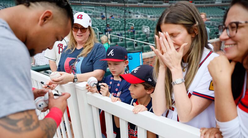 Leslie Tessler gets emotional as she sees Atlanta Braves shortstop Orlando Arcia signing an autograph to her son Lucas Torino (8) before the game against the Chicago Cubs at Truist Park on Tuesday, May 14, 2024. 
(Miguel Martinez/ AJC)