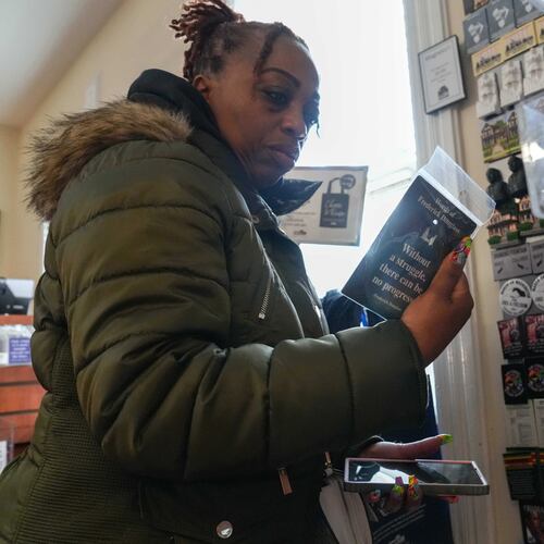 Keisha Burse looks at items for sale at Martin Luther King Jr. National Historical Park, Tuesday, Dec. 9, 2025, in Atlanta. (AP Photo/Megan Varner)