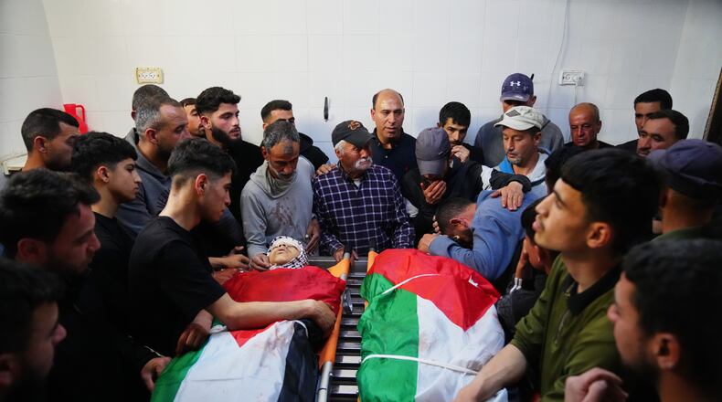 Mourners gather around the bodies of Aws al-Na'san and Jihad Abu Naim, residents of the West Bank village of al-Mughayyir, at the hospital's morgue in the West Bank city of Ramallah, Tuesday, April 21, 2026. (AP Photo/Mahmoud Illean)