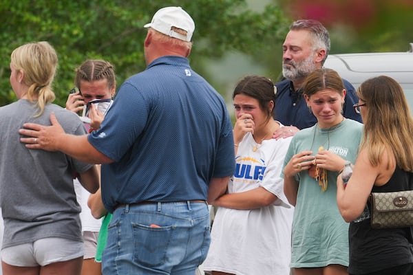 People comfort each other outside the Butt-Holdsworth Memorial Library in Kerville after heavy rainfall caused the Guadalupe River to flood and damage several communities in Central Texas, Saturday, July 5, 2025. (Jason Fochtman/Houston Chronicle via AP)