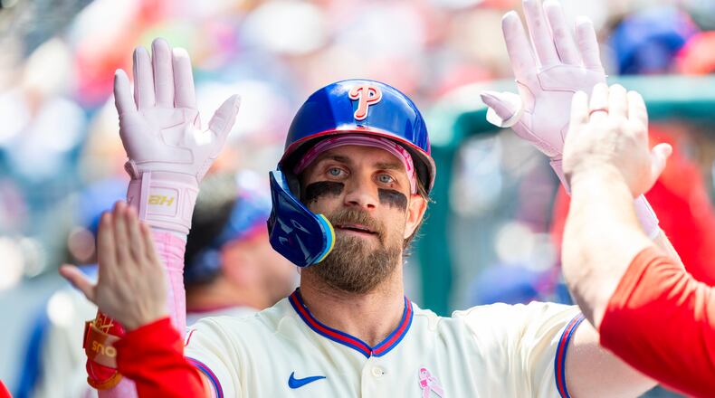 Philadelphia Phillies' Bryce Harper is congratulated in the dugout after he hit a solo home run in the first inning of a baseball game against the Colorado Rockies, Sunday, May 10, 2026, in Philadelphia. (AP Photo/Laurence Kesterson)