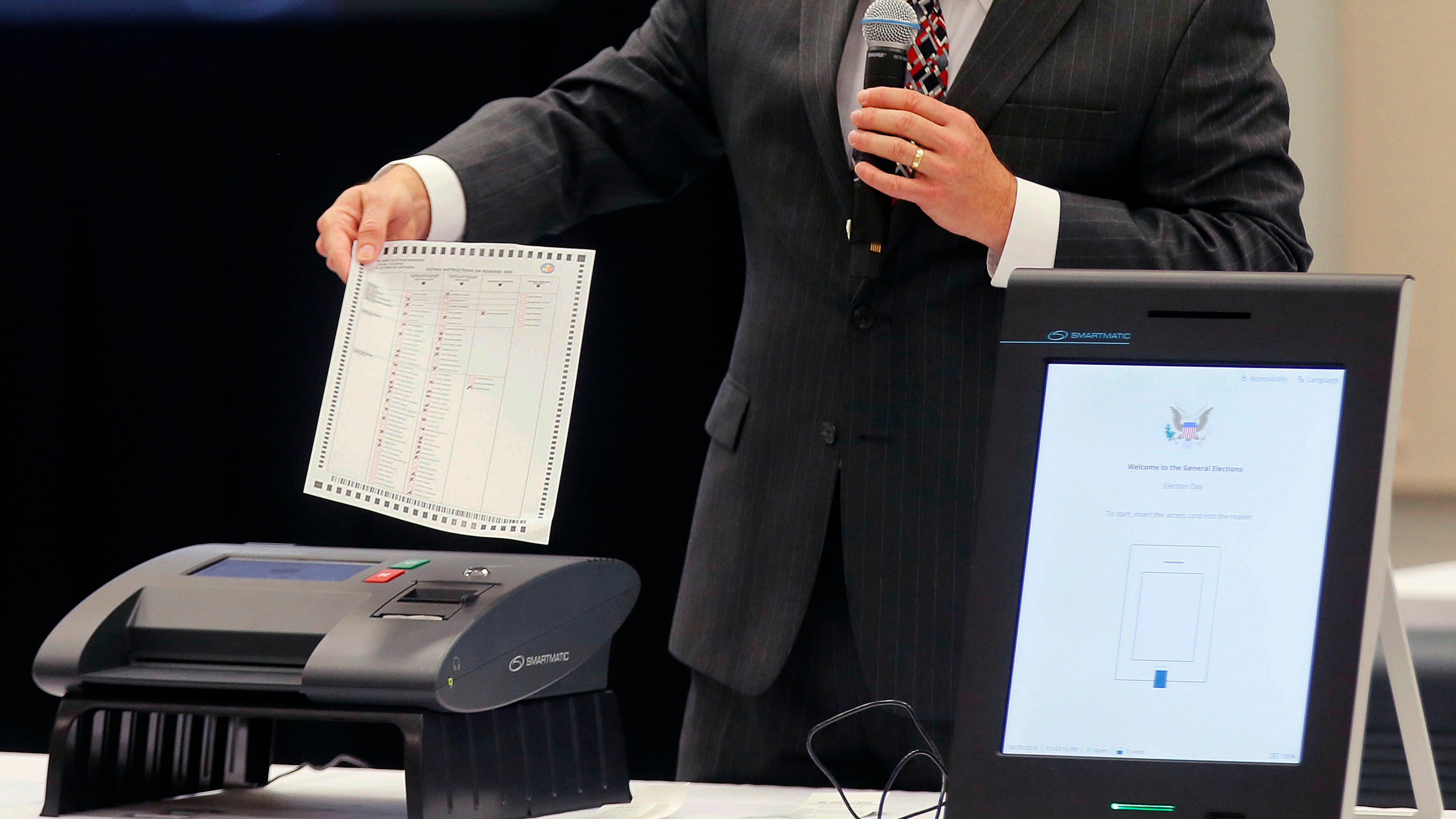 FILE - A Smartmatic representative demonstrates his company's system which has scanners and touch screens with printout options, at a meeting of the Secure, Accessible & Fair Elections Commission, Aug. 30, 2018, in Grovetown, Ga. (Bob Andres/Atlanta Journal-Constitution via AP, File)