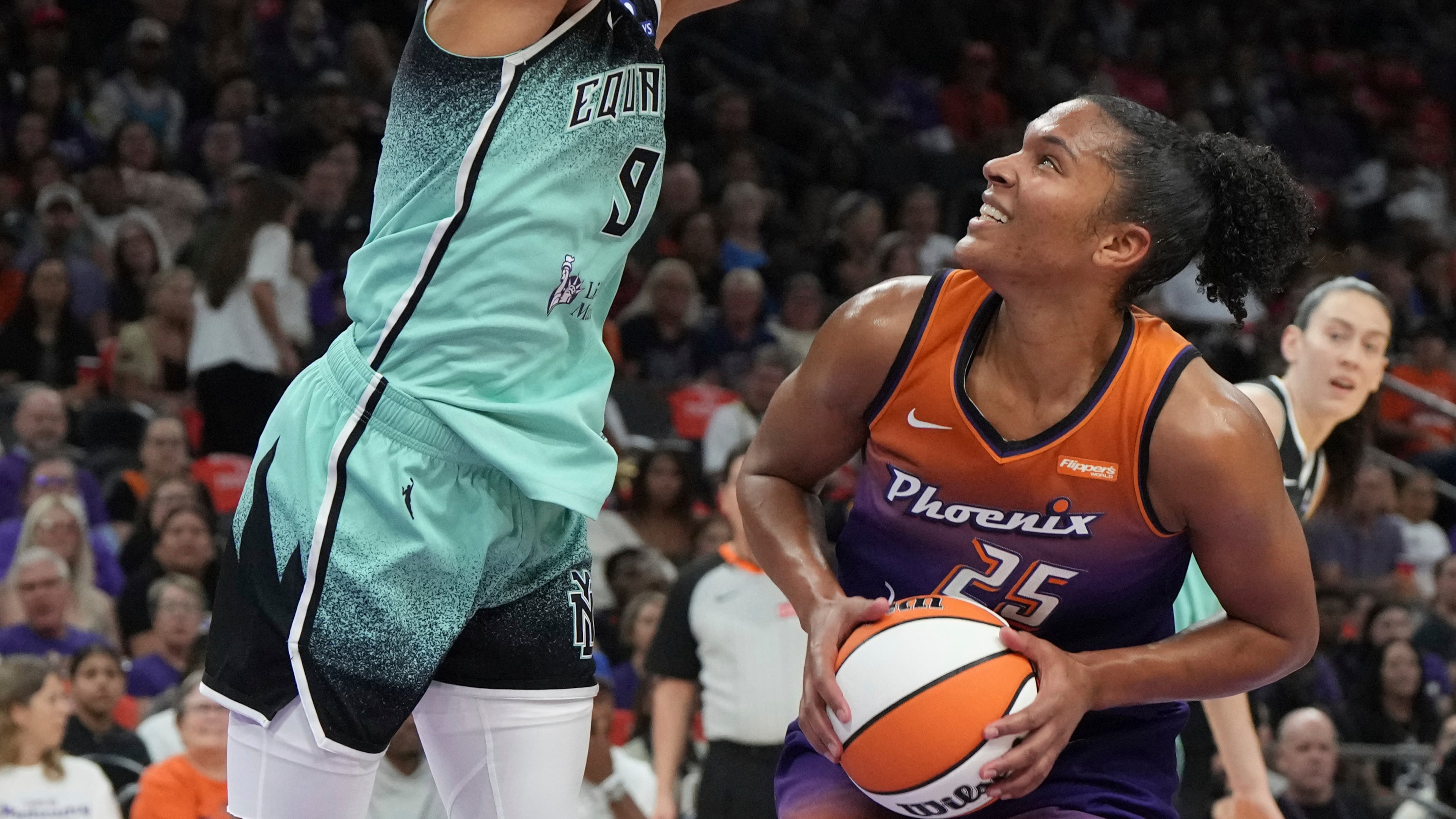 New York Liberty guard Natasha Cloud (9) defends against a shot by Phoenix Mercury forward Alyssa Thomas (25) during the first half of Game 3 in the first round of the WNBA basketball playoffs, Friday, Sept. 19, 2025, in Phoenix. (AP Photo/Rick Scuteri)
