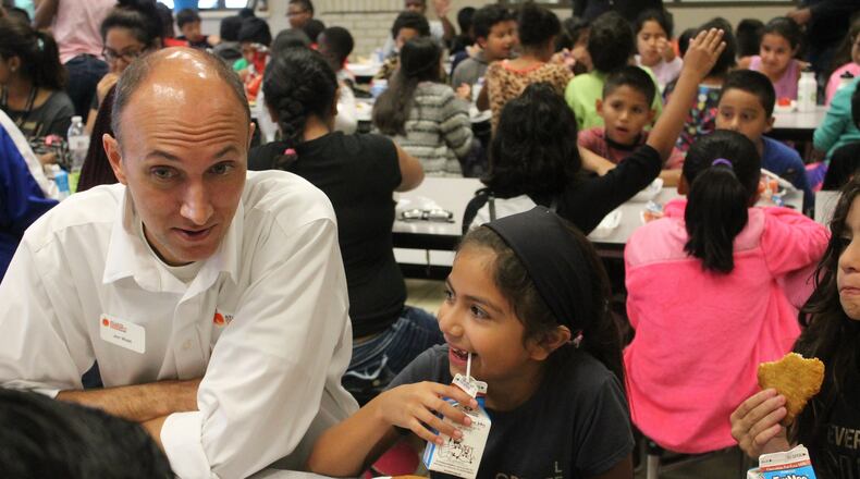 Atlanta Community Food Bank Vice President of Programs Jon West talks with children at a Hall County school during one of the organization’s events promoting summer meals. CONTRIBUTED