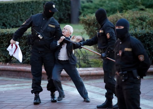 FILE - Opposition activist Nina Bahinskaya, 73, center, struggles with police during a Belarusian opposition supporters rally at Independence Square in Minsk, Belarus, Wednesday, Aug. 26, 2020. (AP Photo/Dmitri Lovetsky, File)