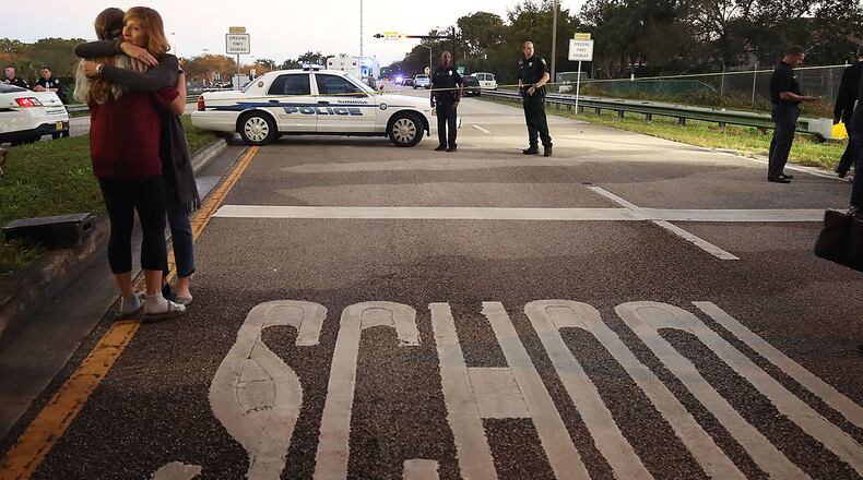 PARKLAND, FL - FEBRUARY 15: Kristi Gilroy (R), hugs a young woman at a police check point near the Marjory Stoneman Douglas High School where 17 people were killed by a gunman on February 15, 2018 in Parkland, Florida. A wide-spread statistic claiming the shooting was the 18th this year is misleading. (Photo by Mark Wilson/Getty Images)