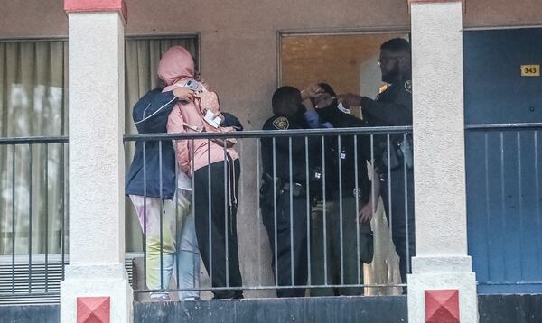Grieving loved ones console each other at the Super 8 motel in College Park after a man was killed Monday morning.