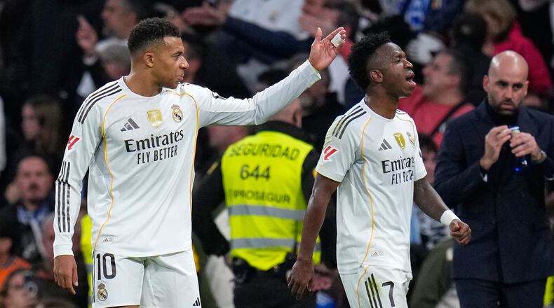 Real Madrid's Kylian Mbappe, left, and Vinicius Junior react during the Spanish La Liga soccer match between Real Madrid and Celta Vigo in Madrid, Spain, Sunday, Dec. 7, 2025. (AP Photo/Manu Fernandez)