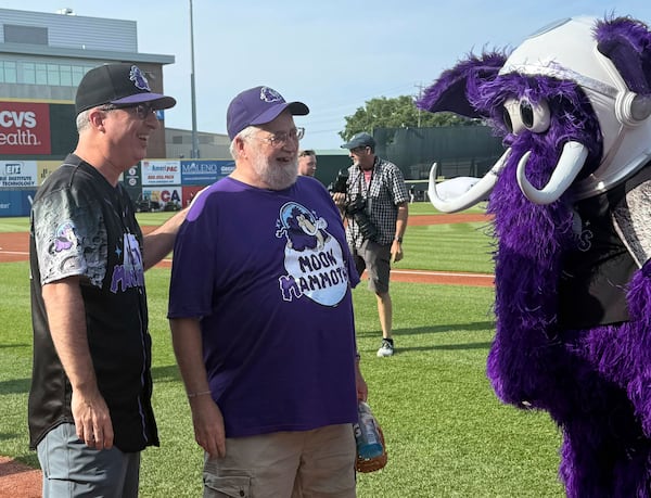 John Oliver, left, and George Moon stand with Fuzz E. Mammoth, the Moon Mammoth mascot, before a game between the Chesapeake Oyster Catches and Erie Moon Mammoths at UMPC Park in Erie, Pa., on Saturday, July 19, 2025. (AP Photo/Joe Reedy)