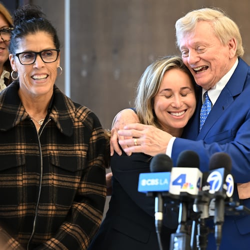 Attorney Russell Hardin Jr. hugs Tyler Skaggs' widow, Carli Skaggs, center, as Skaggs mother's Debbie smiles, at left, after a settlement was reached in the wrongful death lawsuit by the family of the Los Angeles Angels pitcher Friday, Dec. 19, 2025, in Orange County Superior Court, in Santa Ana, Calif. (AP Photo/William Liang)