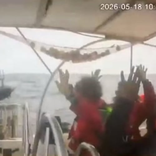 This grab from CCTV footage shows activists aboard a flotilla boat with their hands in the air as a boat approaches one of more than 50 vessels that departed from the port of Marmaris, Turkey, last week in what organizers of the Global Sumud Flotilla described as the final leg of their planned journey to Gaza's shores, in international waters Monday, May 18, 2026. (Global Sumud Flotilla via AP)