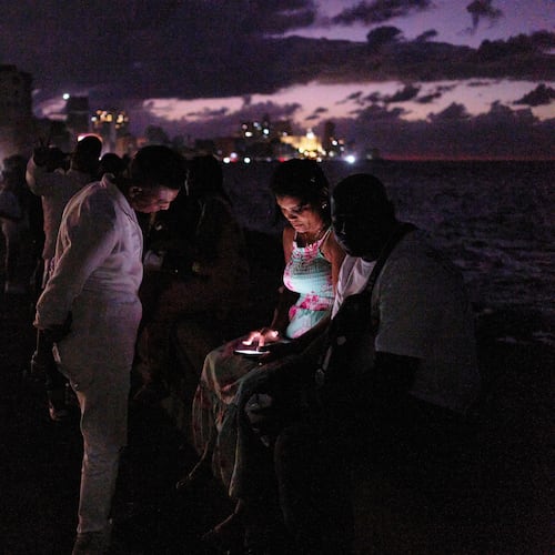 People spend the night in the dark on the Malecon during a blackout in Havana, Cuba, Saturday, March 21, 2026. (AP Photo/Ramon Espinosa)