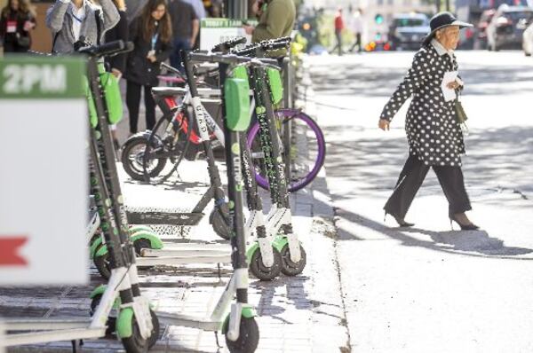 Ride-share scooters sit parked along the sidewalk of Peachtree Street NE in downtown Atlanta. (Alyssa Pointer/Atlanta Journal Constitution)