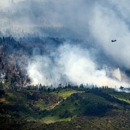 A helicopter drops water on the Cottonwood Fire burning near Beaver, Utah, on Saturday, June 27, 2026. (AP Photo/Noah Berger)