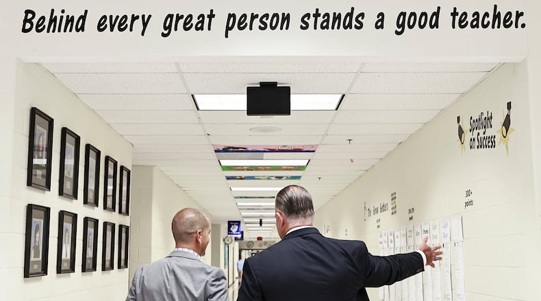 The Cobb County School District will be the first in the state to partner with a college to provide discounted advanced degrees to staff members, the district announced this week. Pictured here, Kemp Elementary Principal Billy Pritz (left) gives Superintendent Chris Ragsdale (right) a tour of the school on Monday, Aug. 1, 2022, under a slogan commending teachers. (Natrice Miller/natrice.miller@ajc.com)