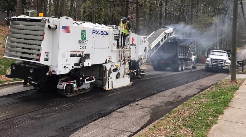 Crews repave a street in a Dunwoody neighborhood.
