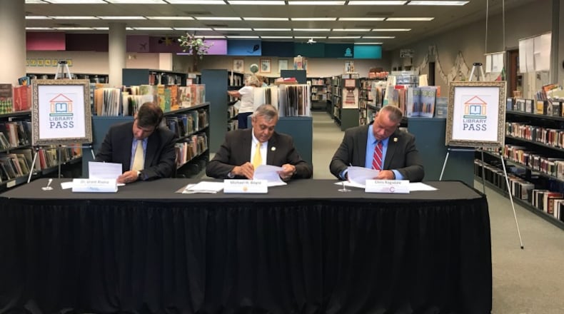 During a ceremony at the Switzer Library in Marietta on June 20, left to right, Superintendent Grant Rivera, Marietta City Schools; Chairman Mike Boyce, Cobb County Board of Commissioners and CCSD Superintendent Chris Ragsdale signed an agreement to extend the Library PASS partnership for two years. Courtesy of Cobb County School District