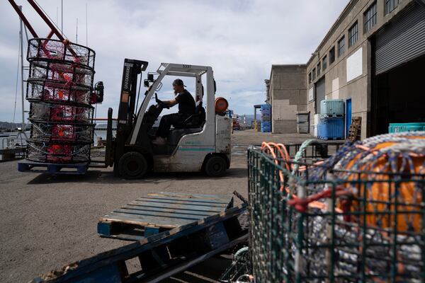 Justin Middleton transports crab traps past pop-up gear, right, used to protect whales, at Pier 45 in San Francisco, Thursday, April 10, 2025. (AP Photo/Emily Steinberger)