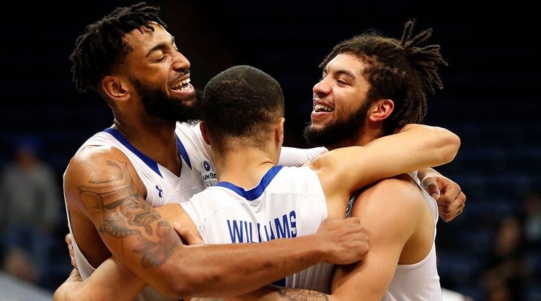 Georgia State forward Jordan Session, left, guard D'Marcus Simonds, right, and guard Isaiah Williams, center, celebrate in the final minute of the second half in their victory over Texas-Arlington in the the Sun Belt Conference NCAA college basketball championship game in New Orleans, Sunday, March 11, 2018. Georgia State won 74-61. (AP Photo/Gerald Herbert)