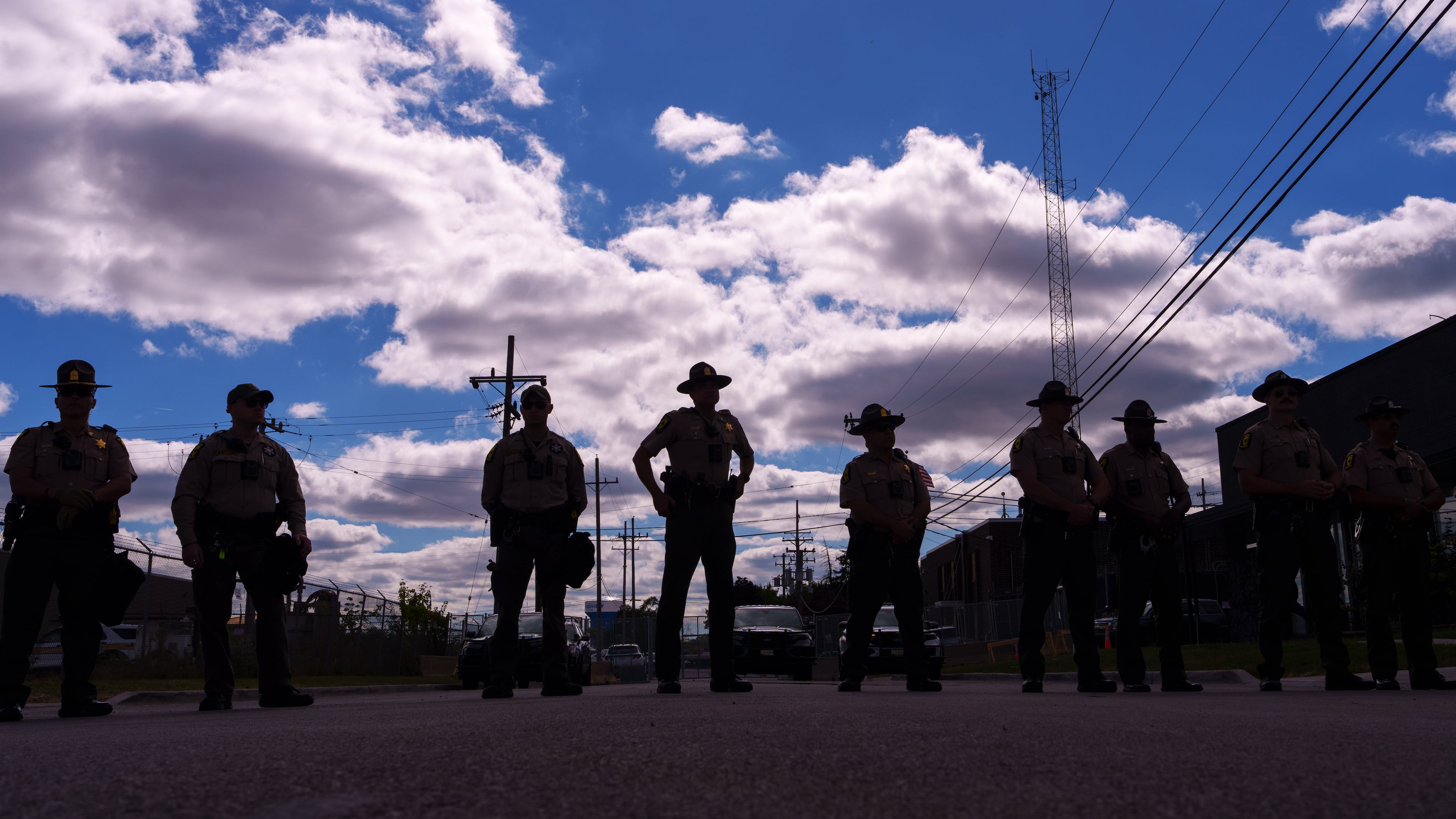 Illinois State Police stand guard as people including members of the Coalition for Spiritual and Public Leadership (CSPL) gather outside a U.S. Immigration and Customs Enforcement facility in Broadview, Ill., Saturday, Oct. 11, 2025. (AP Photo/Adam Gray)