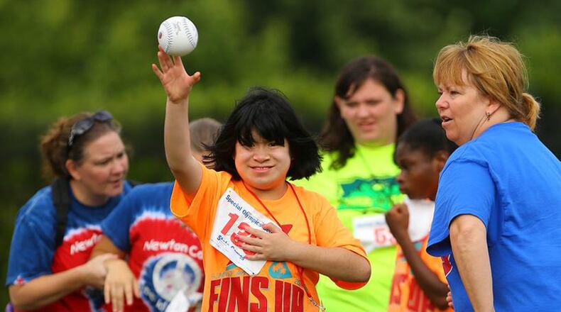 Kelsi Bollinger, 14, Fulton County Schools, makes her toss with a smile in the softball throw during the Georgia Special Olympics State Games. CURTIS COMPTON/AJC FILE