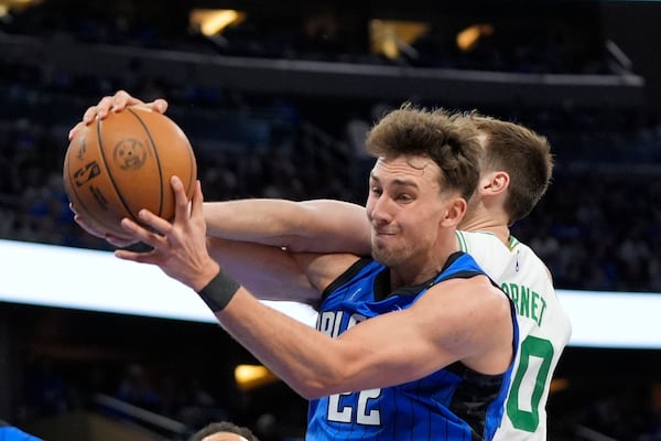 Orlando Magic forward Franz Wagner (22) collects a rebound in front of Boston Celtics center Luke Kornet during the first half in game 3 of a first-round NBA playoff basketball series,, Friday, April 25, 2025, in Orlando, Fla. (AP Photo/John Raoux)