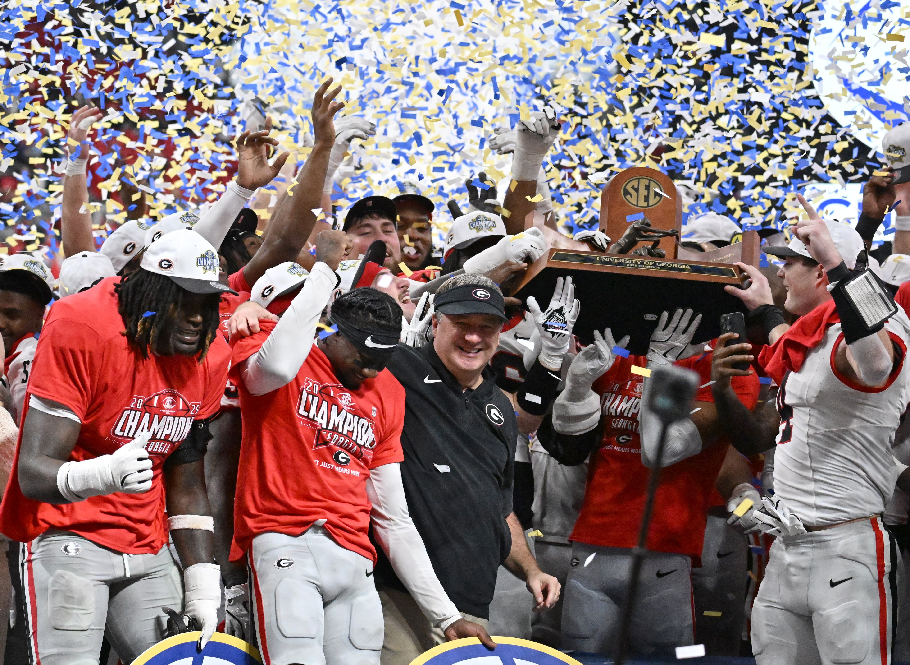 Georgia head coach Kirby Smart and players celebrate after defeating Alabama 28-7 in the SEC Championship football game at the Mercedes-Benz Stadium, Saturday, December 6, 2025 in Atlanta. (Hyosub Shin / AJC)