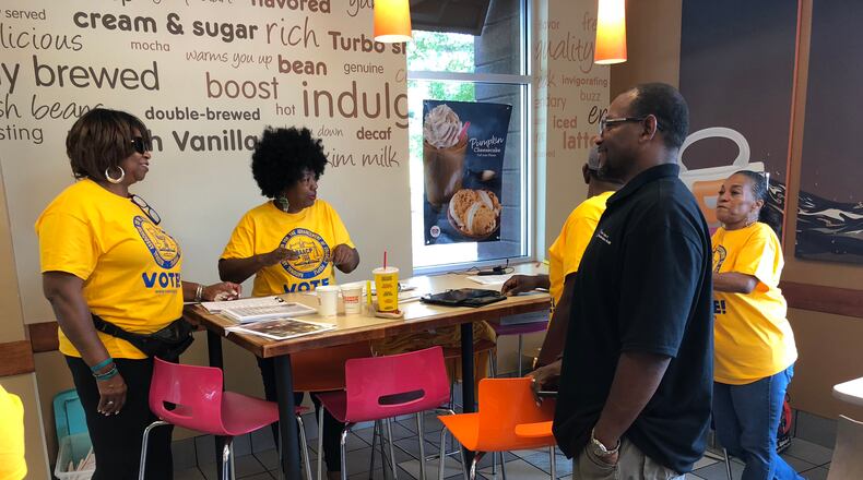 Clayton County NAACP president Cheryl Synamon Baldwin, center, talks to volunteers before they fan out to register voters who had been purged from the voting rolls in the south metro community. LEON STAFFORD/AJC