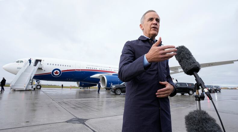Canada Prime Minister Mark Carney speaks with members of the media before he boards a government plane in Ottawa on Friday Oct. 24, 2025. (Adrian Wyld/The Canadian Press via AP)