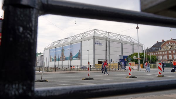 The fire-damaged Old Stock Exchange building is shrouded by a white construction tent in Copenhagen, Denmark, Monday, June 23, 2025. (AP Photo/James Brooks)