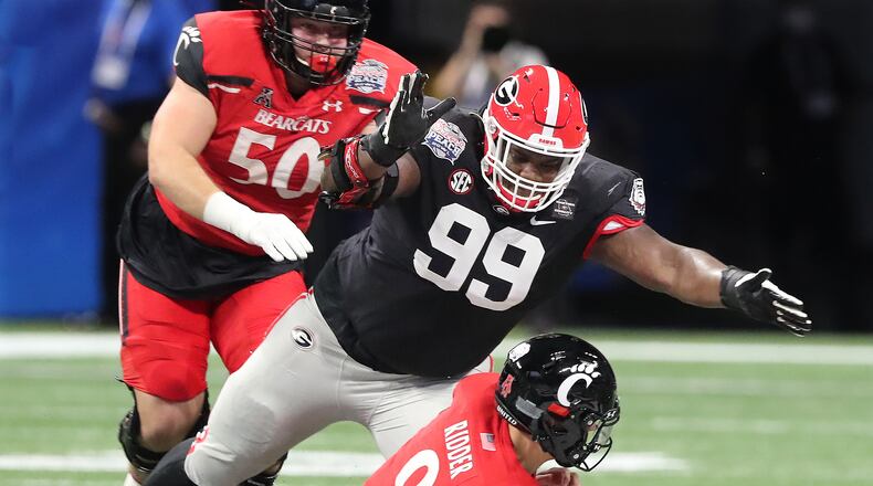 Georgia defensive lineman Jordan Davis smothers Cincinnati quarterback Desmond Ridder for a sack during the first half.    Curtis Compton / Curtis.Compton@ajc.com”