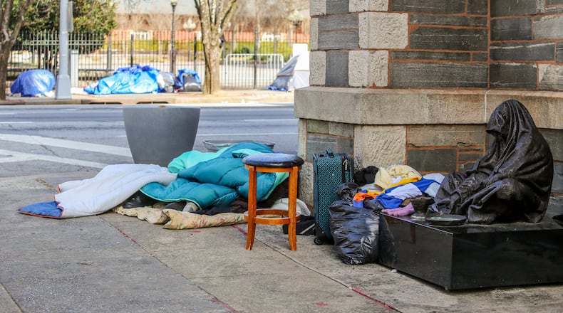 Homeless gather along Martin Luther King, Jr Blvd and some sleep on the steps of the Catholic Shrine of the Immaculate Conception on Wednesday, Jan 20, 2021. Atlanta City Council wants the mayor to identify a sustainable revenue stream to support the city's homeless community. (Jenni Girtman for The Atlanta Journal-Constitution)