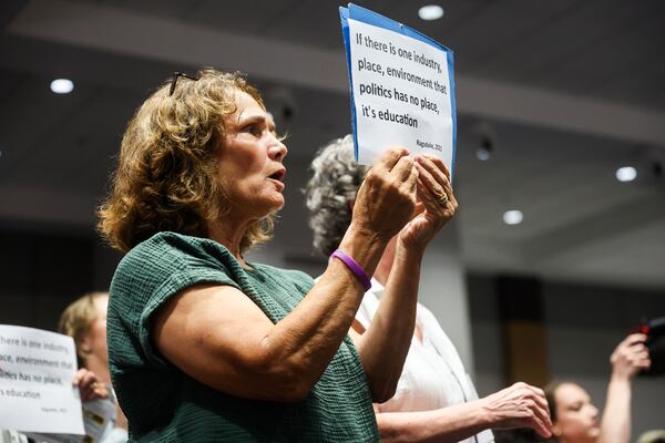Rose Caplan holds up a sign during a Cobb County school board meeting in Marietta, on Thursday, July 23, 2026. (Abbey Cutrer/AJC)
