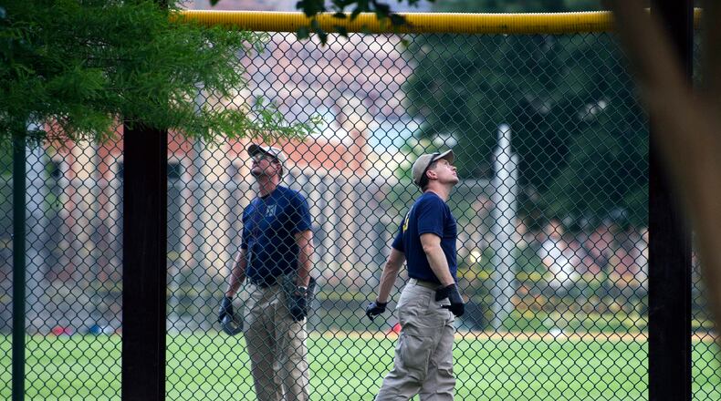 A FBI lab team looks for evidence in the outfield signage at the ball field which is the scene of a multiple shooting in Alexandria, Va., on Wednesday. (AP Photo / Cliff Owen)